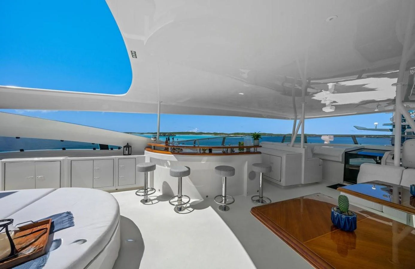 The flybridge offers a luxurious space with a bar, seating, and stunning ocean views. aboard BLACK SHEEP Yacht for Sale
