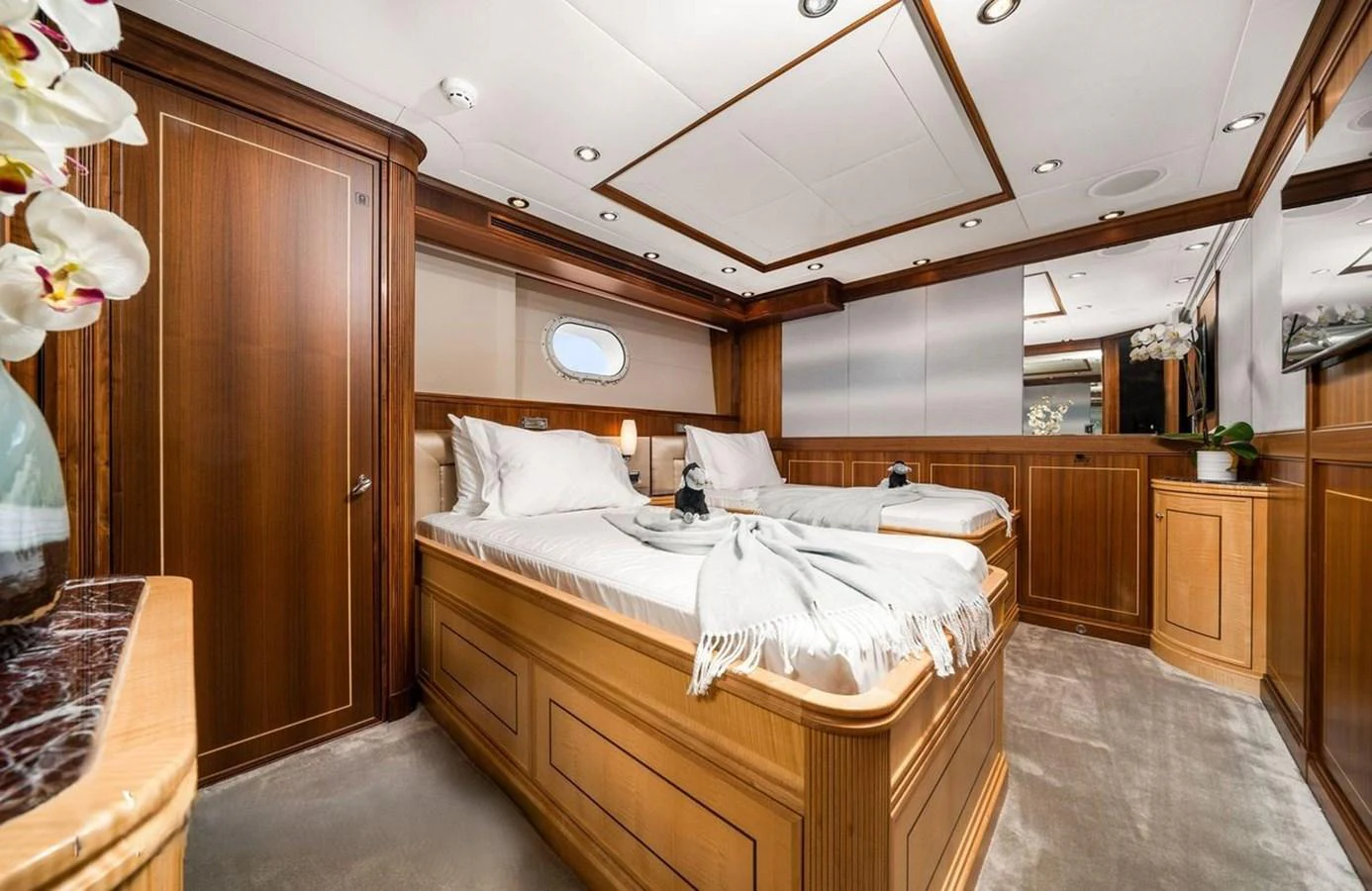 The guest stateroom features twin beds with luxurious bedding and elegant wood paneling. aboard BLACK SHEEP Yacht for Sale