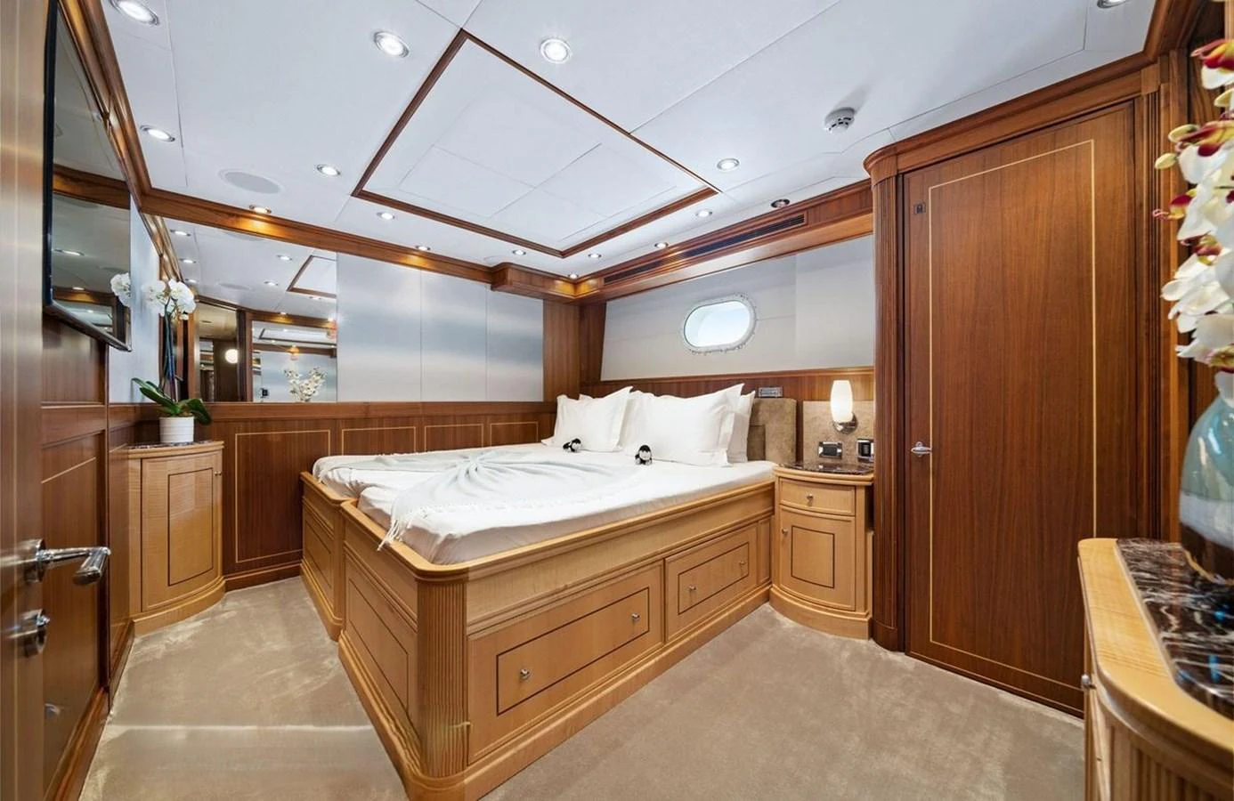 The stateroom features luxurious wood paneling and a plush bed, creating a cozy and elegant retreat. aboard BLACK SHEEP Yacht for Sale