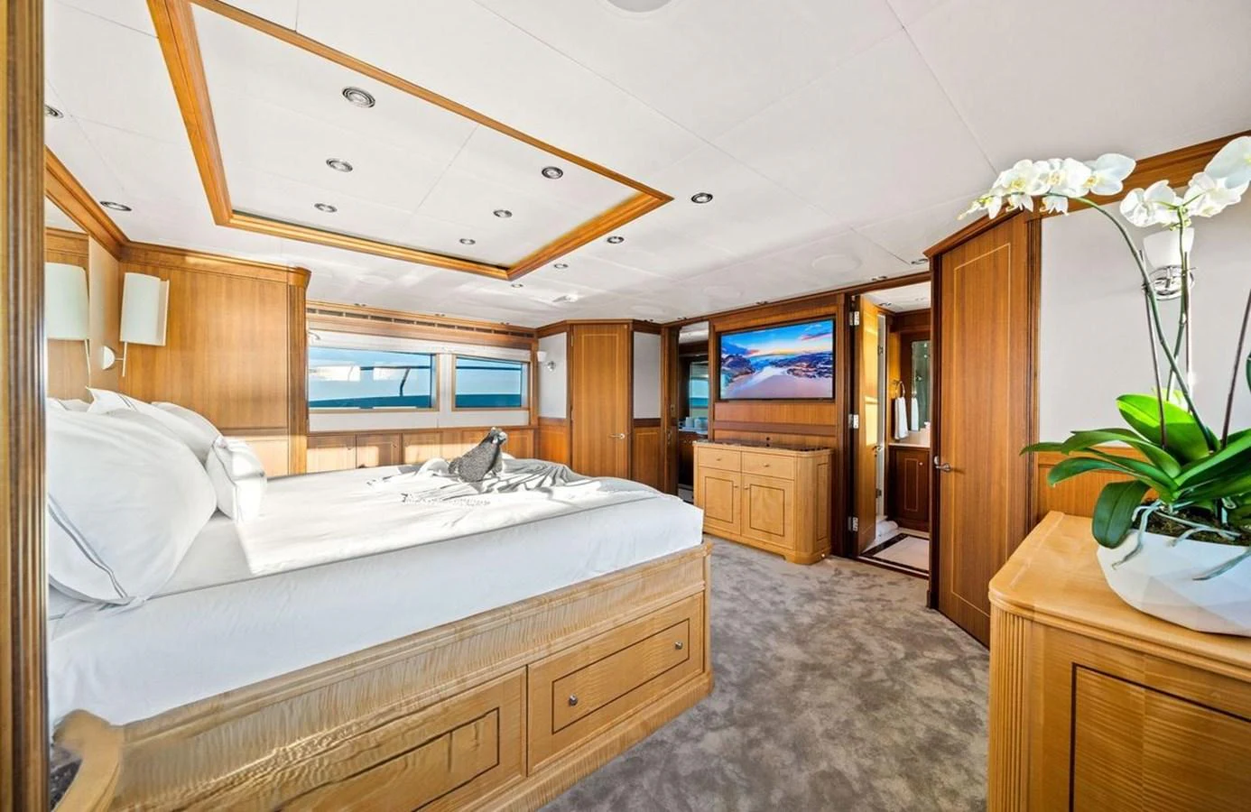 The master stateroom features a spacious bed, elegant wood finishes, and ample natural light. aboard BLACK SHEEP Yacht for Sale