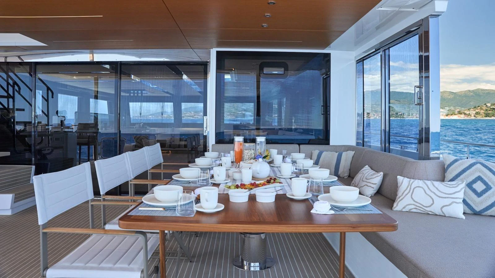 The aft deck features a beautifully set dining table with a stunning ocean view. aboard ATRAVERSIA Yacht for Sale