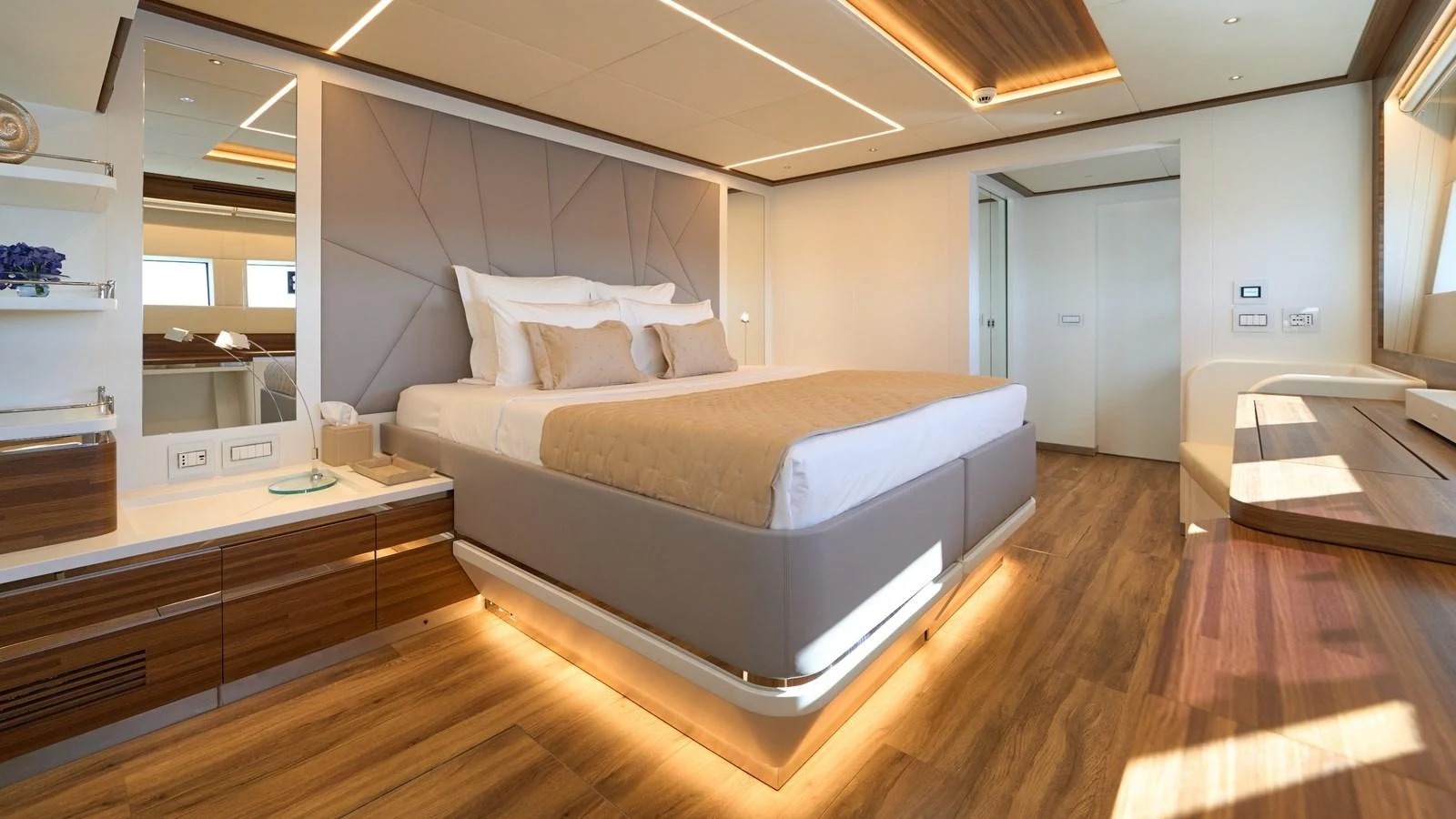 The master stateroom features a luxurious bed with elegant lighting and modern decor. aboard ATRAVERSIA Yacht for Sale