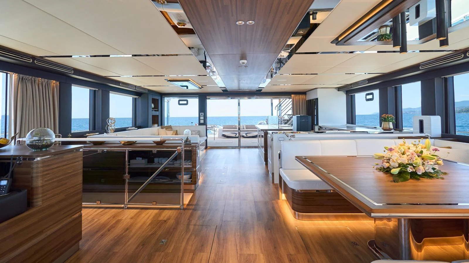 The spacious salon features elegant wood finishes and ample natural light, creating a luxurious and inviting atmosphere. aboard ATRAVERSIA Yacht for Sale