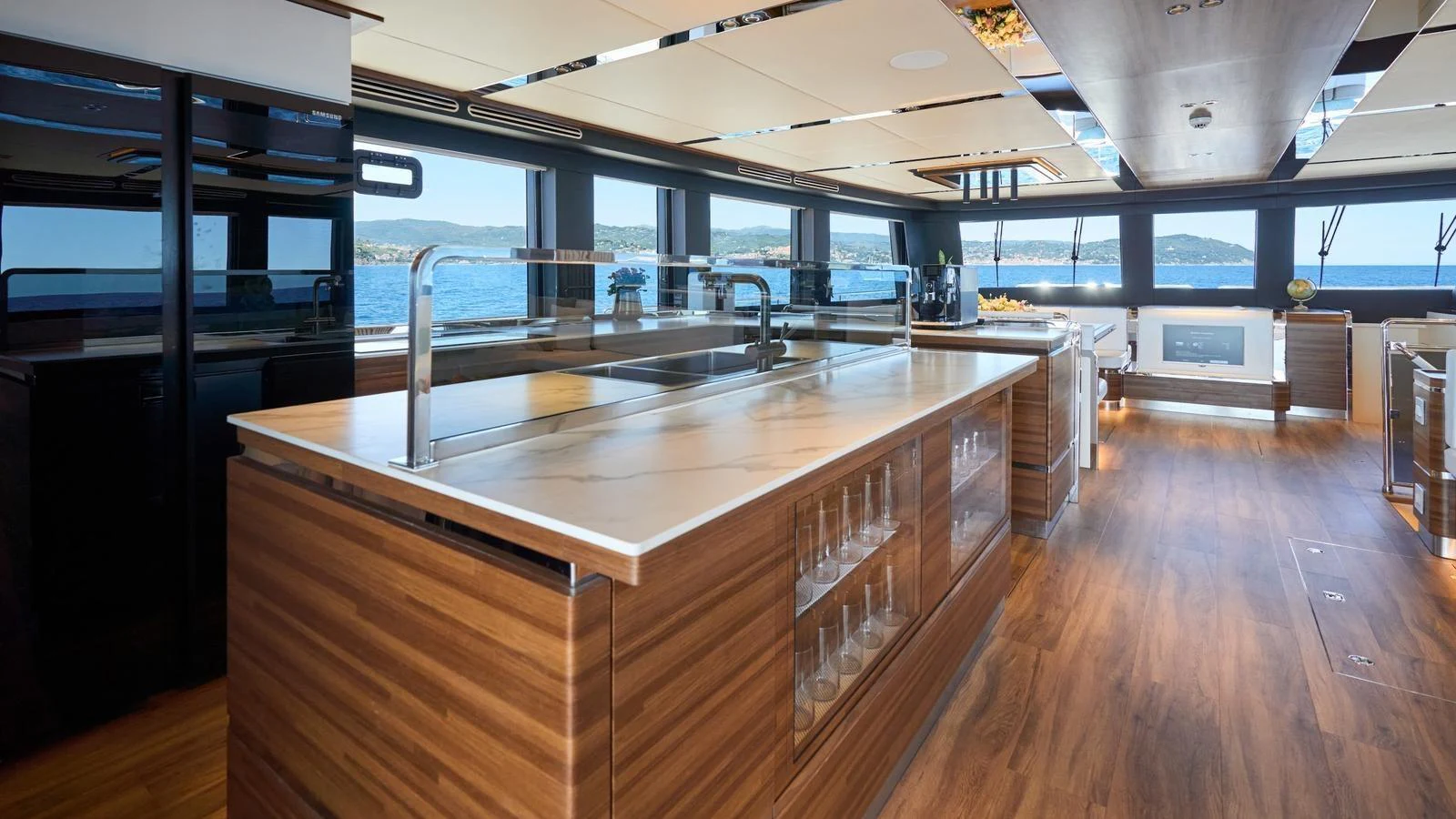 The galley features modern appliances and elegant wooden finishes, offering a spacious and luxurious cooking area with stunning sea views. aboard ATRAVERSIA Yacht for Sale