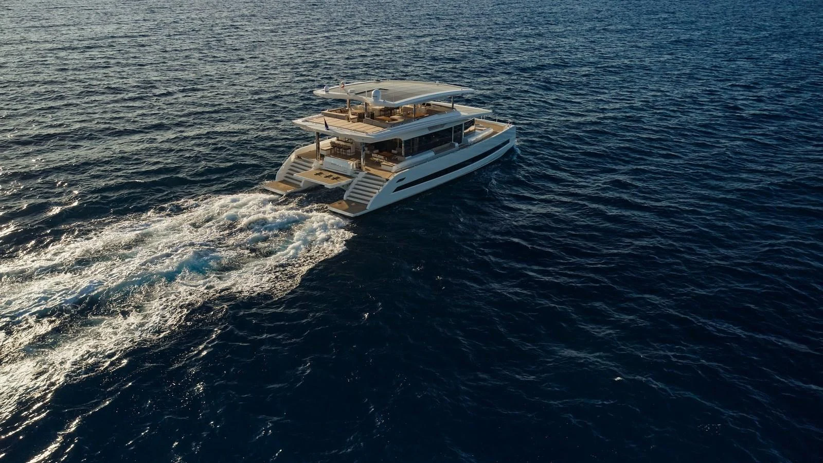 A sleek and modern yacht glides effortlessly across the open sea. aboard ATRAVERSIA Yacht for Sale