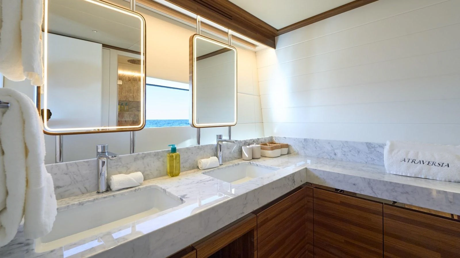 The yacht's bathroom features a luxurious double sink setup with elegant marble countertops and modern lighting. aboard ATRAVERSIA Yacht for Sale