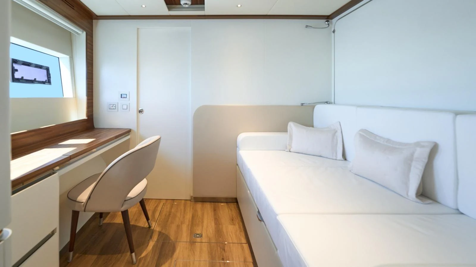 A cozy cabin featuring a comfortable sofa and a work desk with a chair. aboard ATRAVERSIA Yacht for Sale