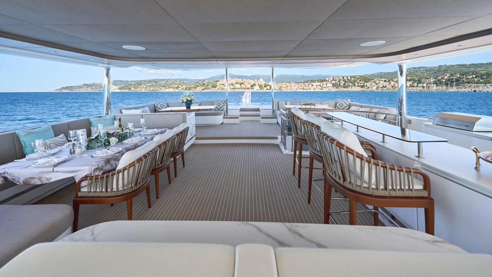 The aft deck offers a spacious and elegant dining area with panoramic ocean views. aboard ATRAVERSIA Yacht for Sale