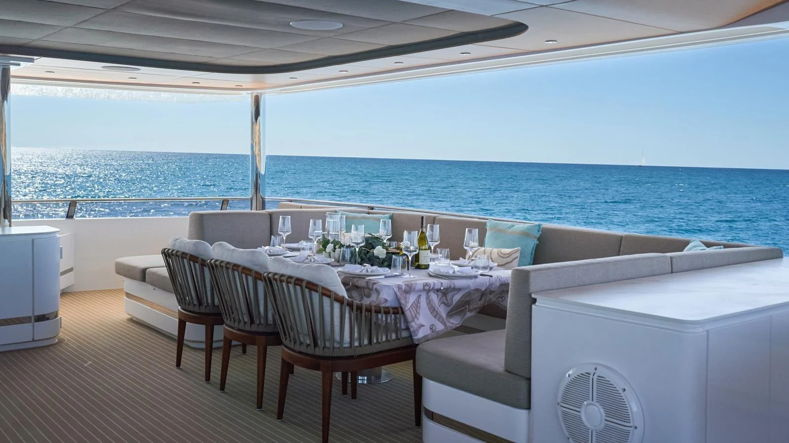 The aft deck features an elegant dining area with panoramic ocean views. aboard ATRAVERSIA Yacht for Sale