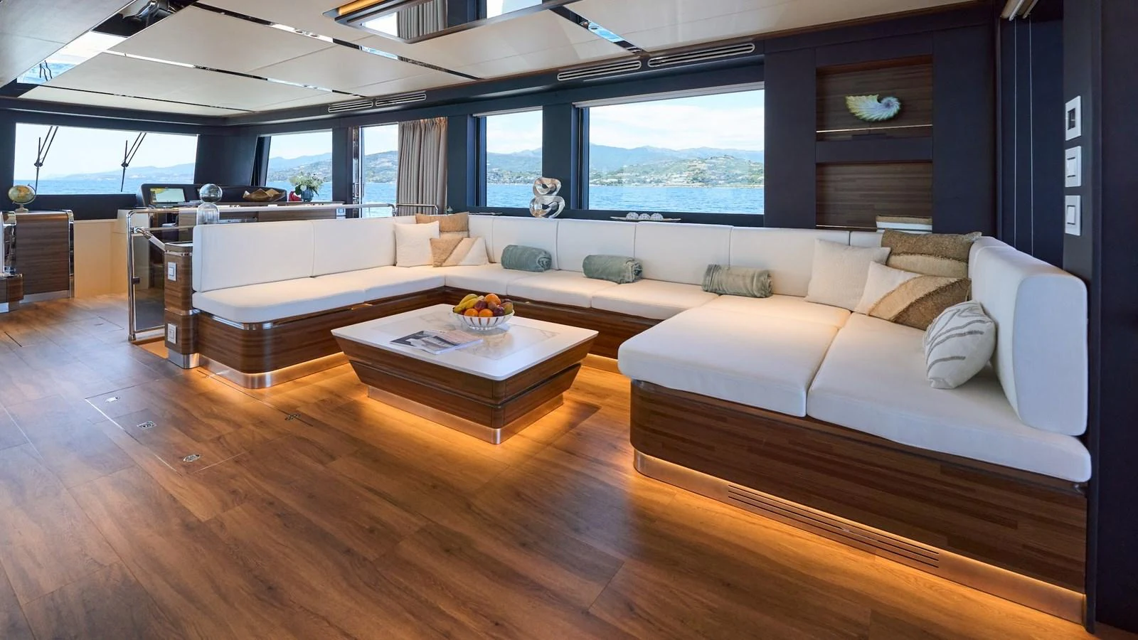 The salon features a spacious and elegant seating area with panoramic windows offering stunning views. aboard ATRAVERSIA Yacht for Sale