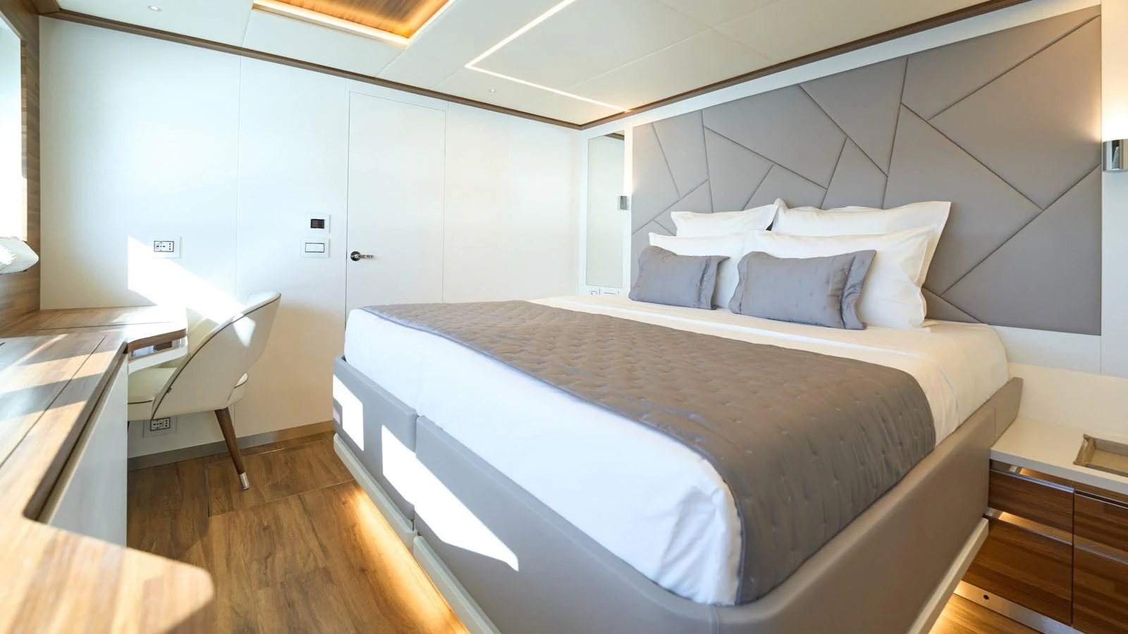 The stateroom features a spacious bed with modern decor and ample natural light. aboard ATRAVERSIA Yacht for Sale