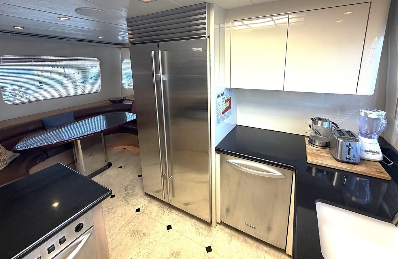This modern galley features sleek stainless steel appliances and ample counter space. aboard HATTERAS 92' Yacht for Sale