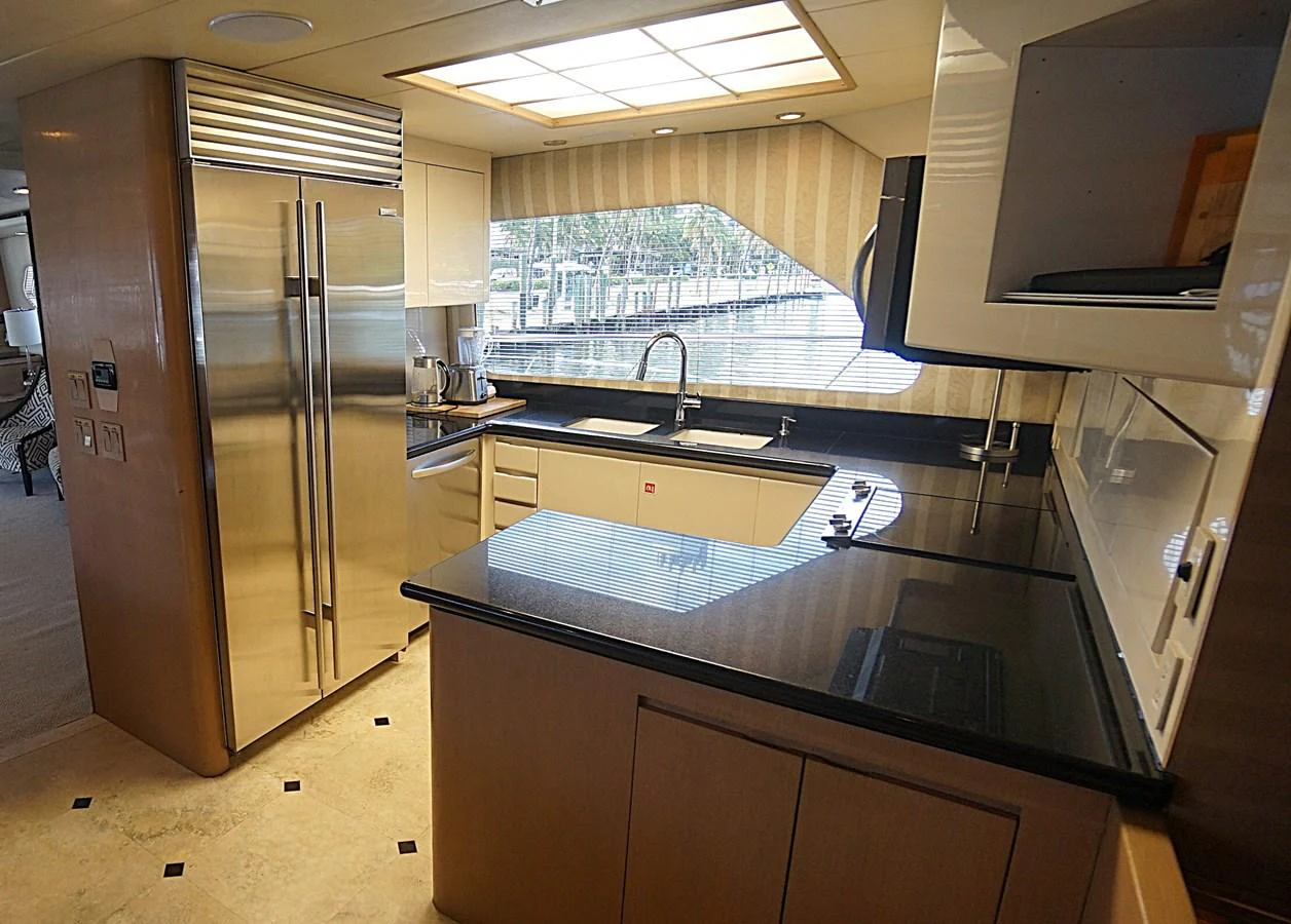The galley features modern appliances and ample counter space, perfect for gourmet meal preparation. aboard HATTERAS 92' Yacht for Sale