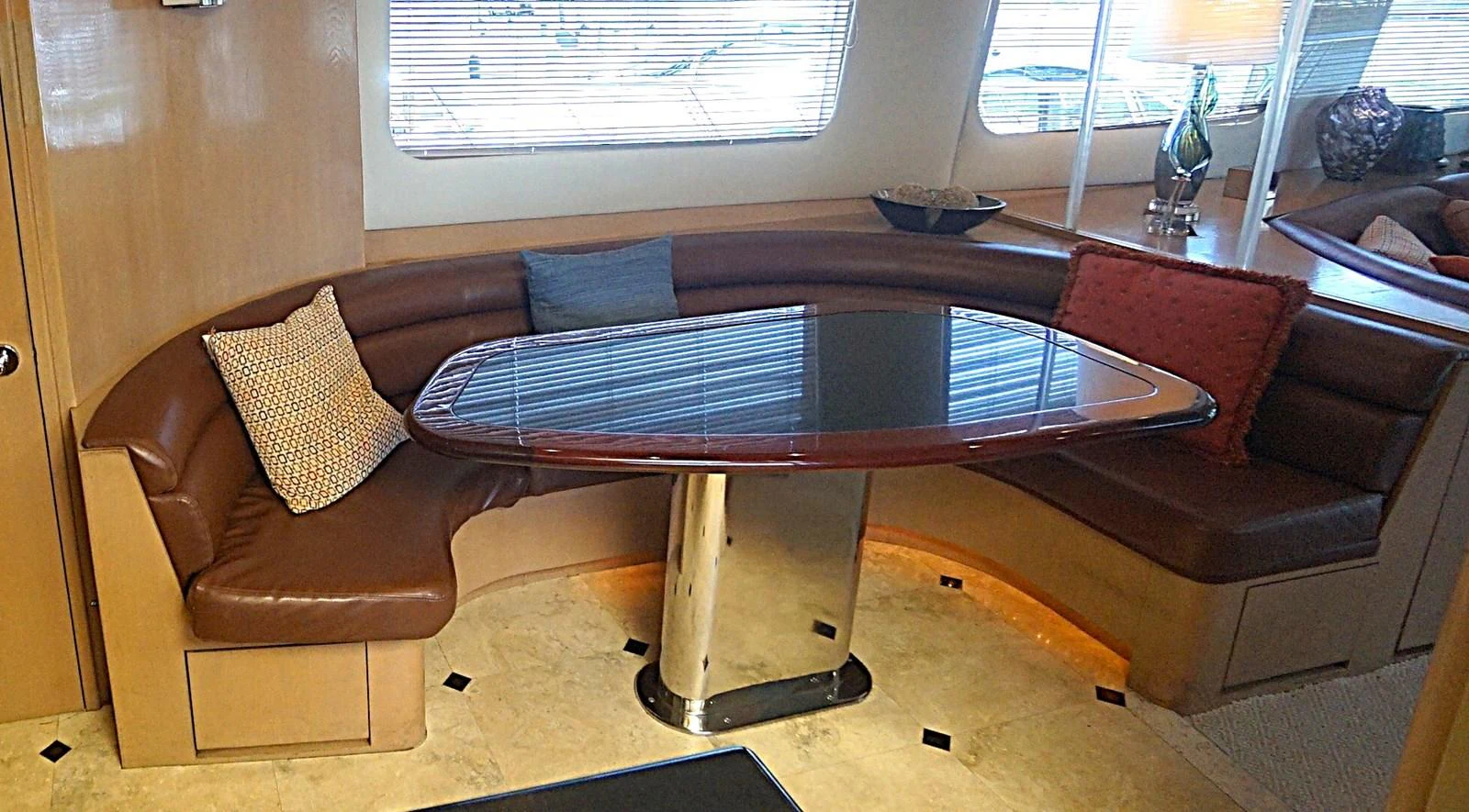 The yacht's dining area features a sleek table surrounded by comfortable seating and stylish decor. aboard HATTERAS 92' Yacht for Sale