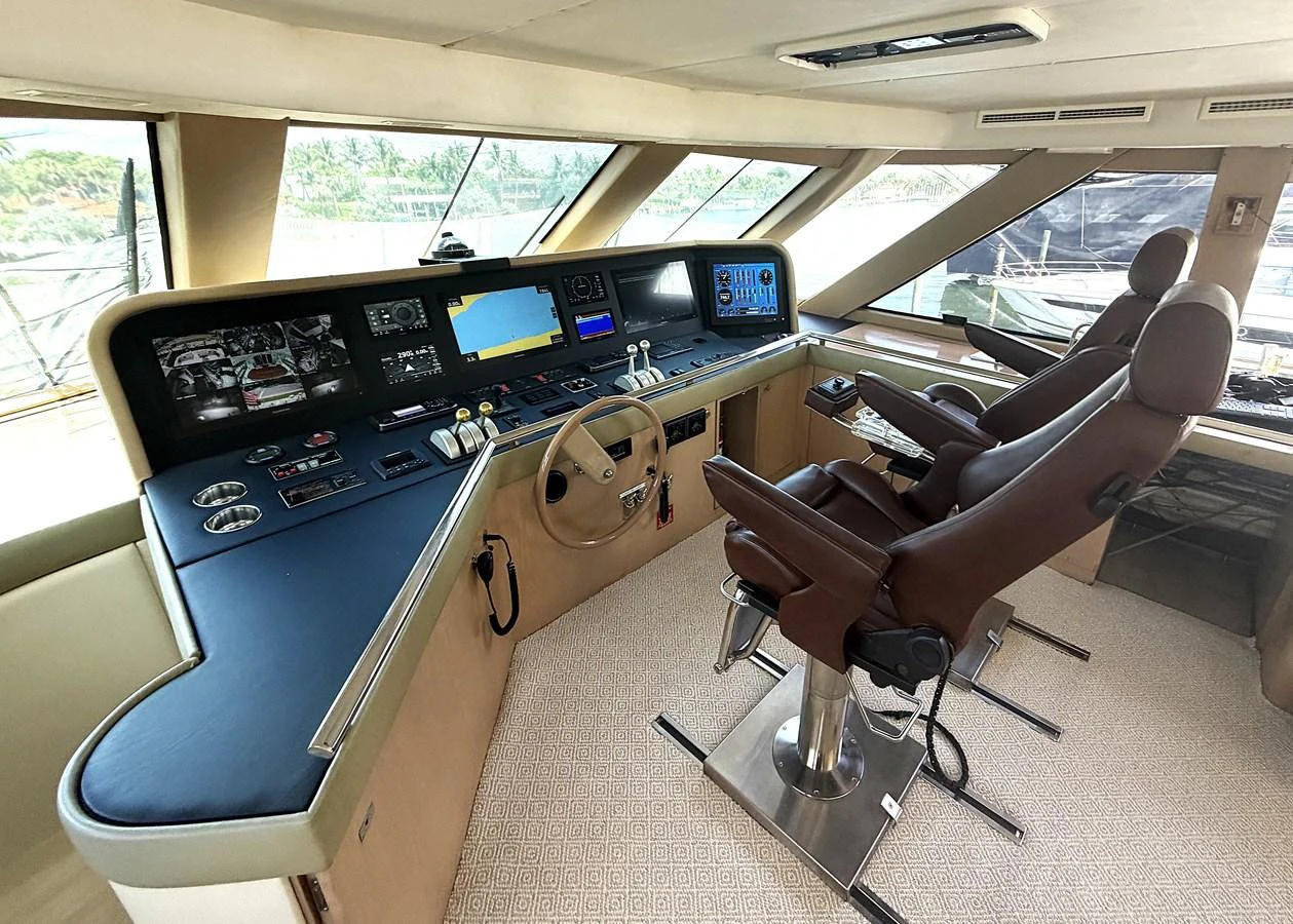 The helm station features advanced navigation equipment and comfortable seating for the captain and co-pilot. aboard HATTERAS 92' Yacht for Sale