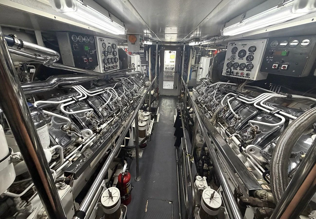 The image showcases the meticulously maintained engine room of the yacht, featuring advanced machinery and control panels. aboard HATTERAS 92' Yacht for Sale