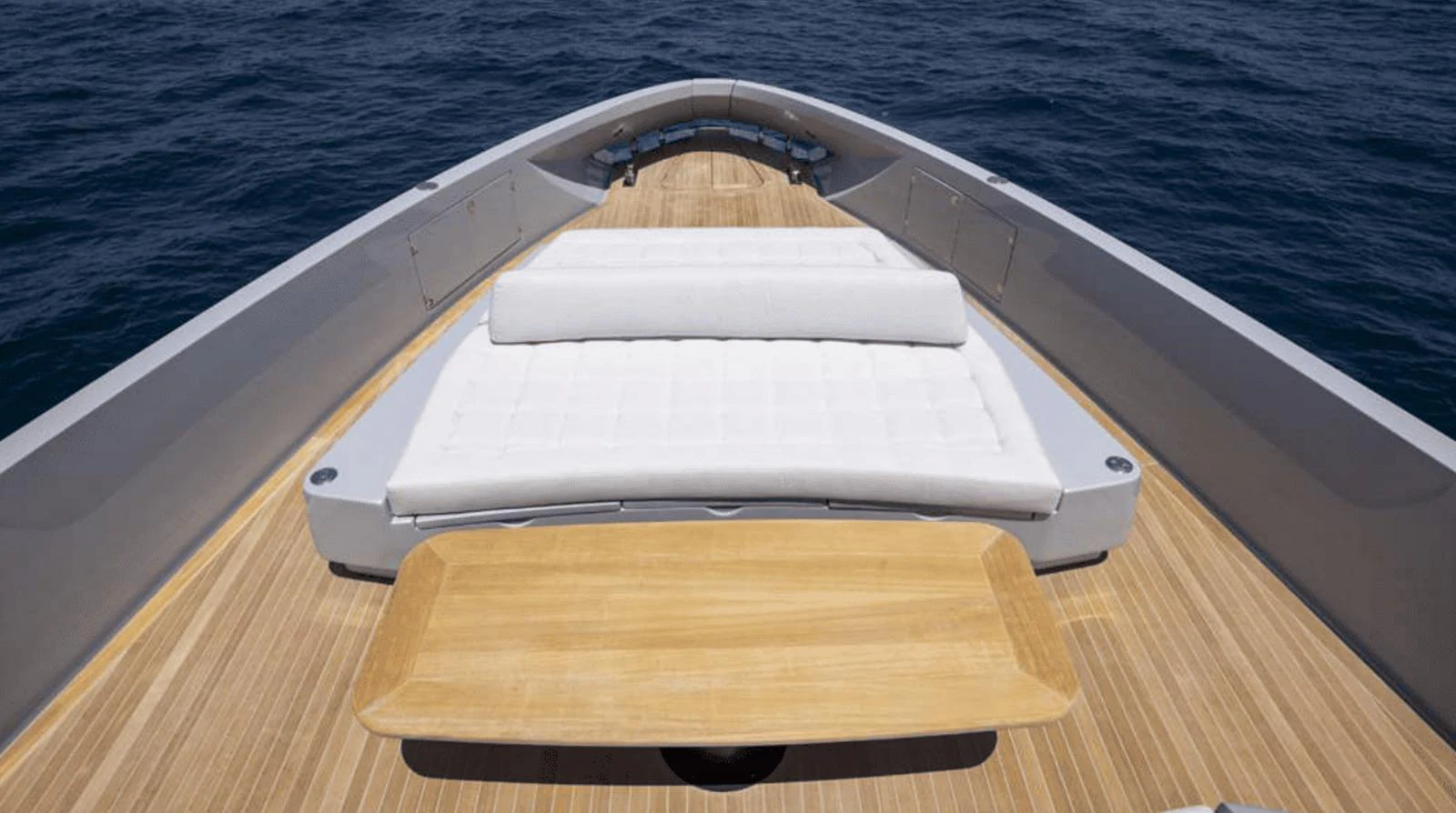 The foredeck features a spacious sunbathing area with a comfortable lounge and a wooden table, perfect for relaxation. aboard MANDAYACHT S07 SPIDER Yacht for Sale