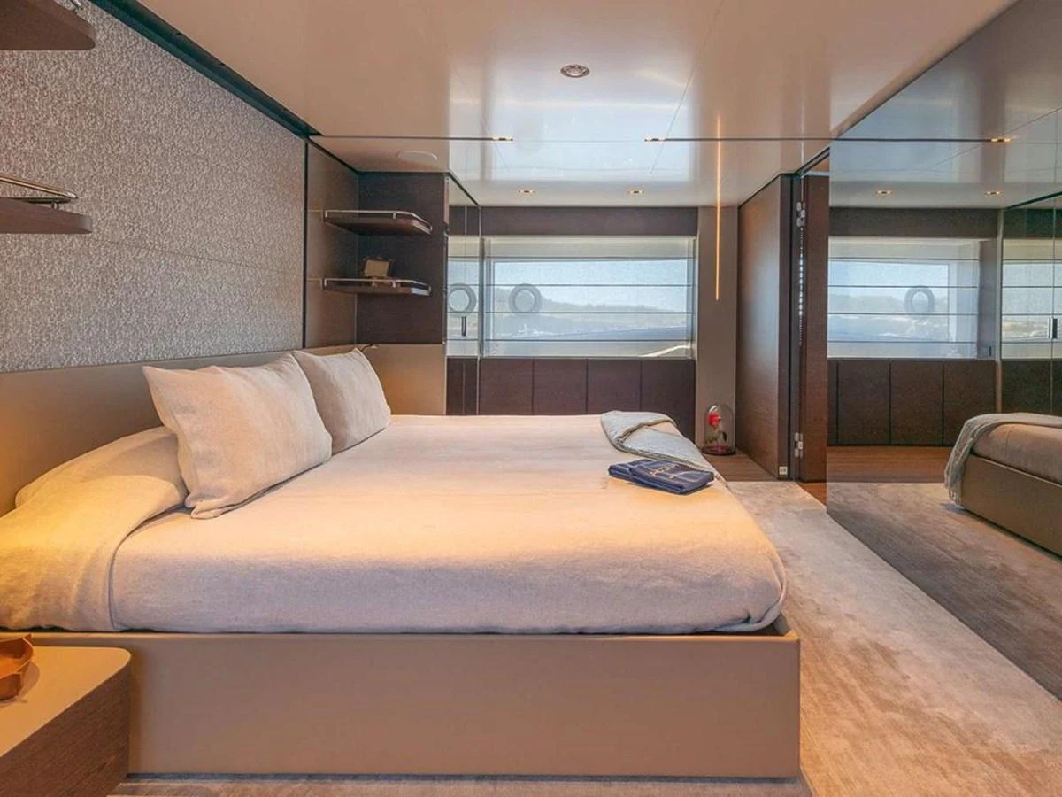 The stateroom features a spacious bed with modern decor and ample natural light. aboard ON Yacht for Sale