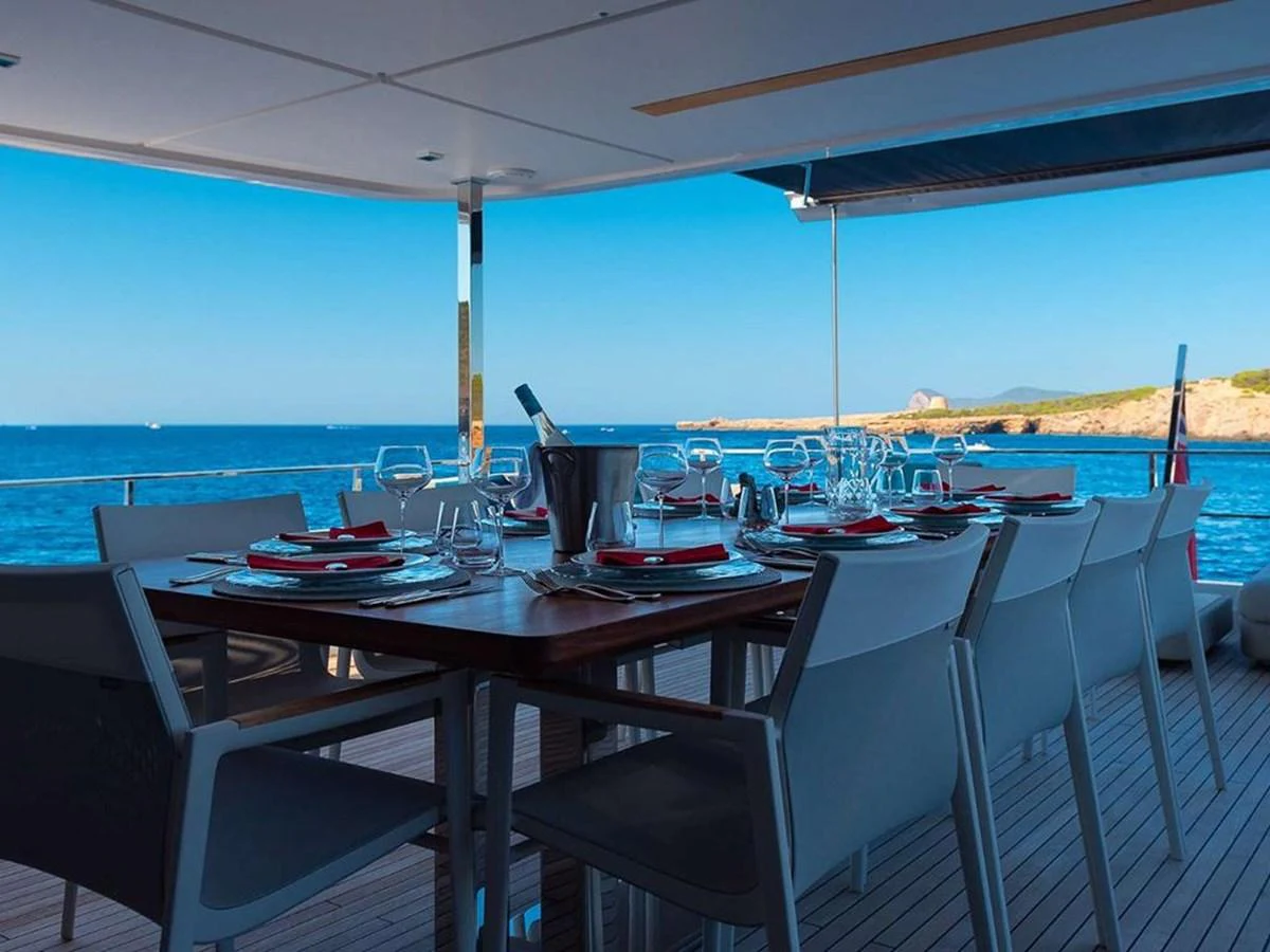 The aft deck features an elegant dining area with a stunning ocean view. aboard ON Yacht for Sale