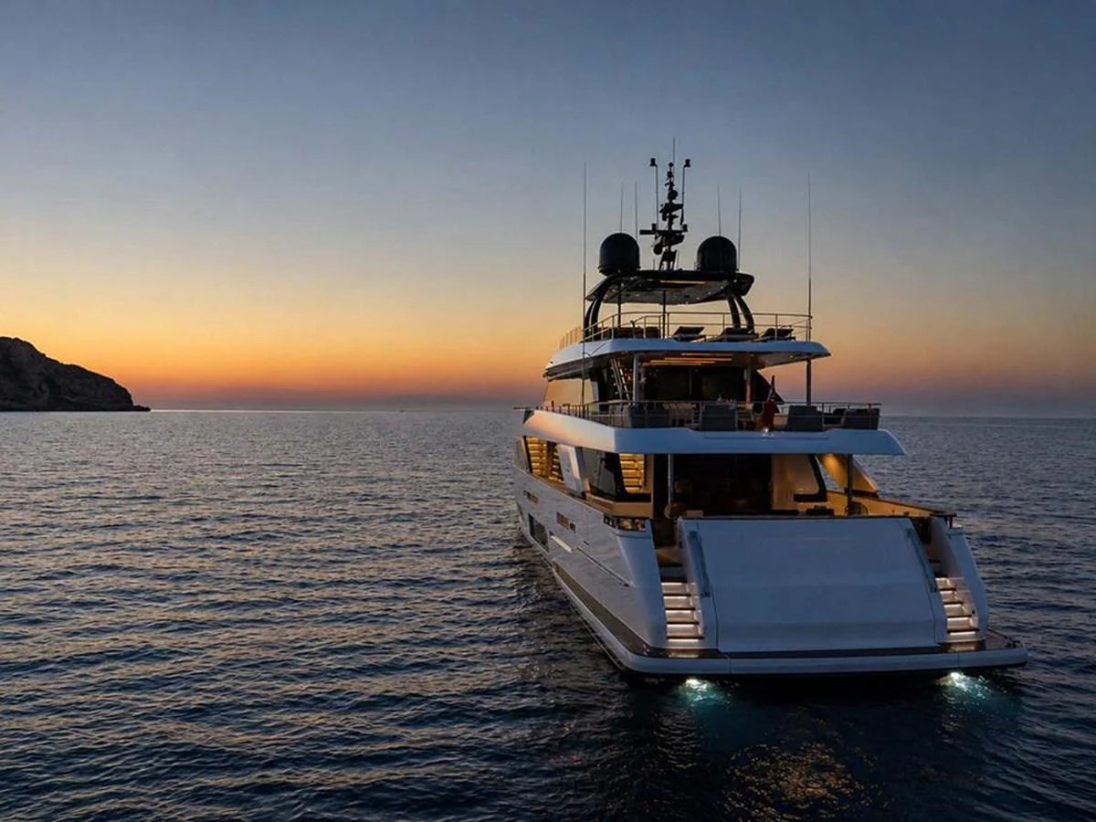 A luxurious yacht is anchored on calm waters at sunset, showcasing its elegant design and inviting ambiance. aboard ON Yacht for Sale
