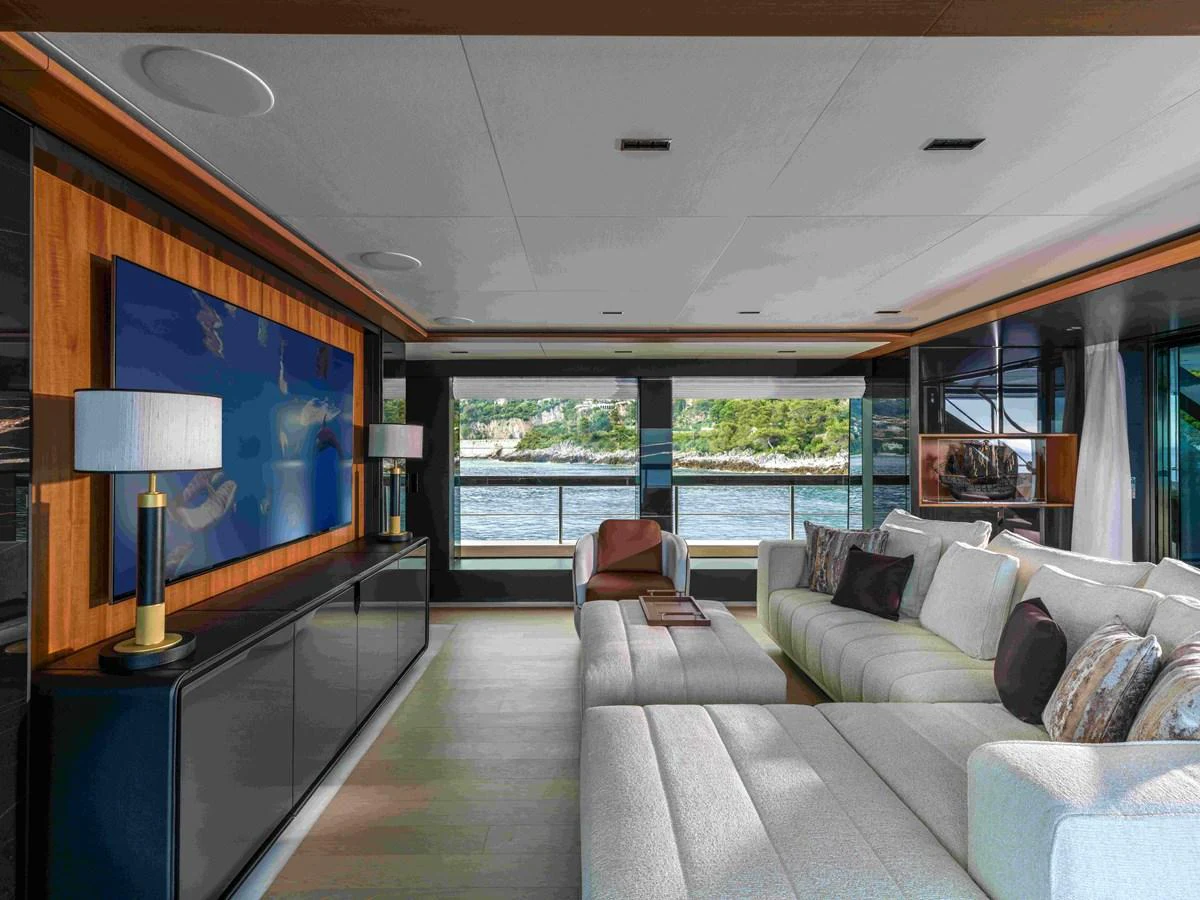 The salon features a spacious and luxurious seating area with large windows offering stunning views. aboard SAIRU Yacht for Sale