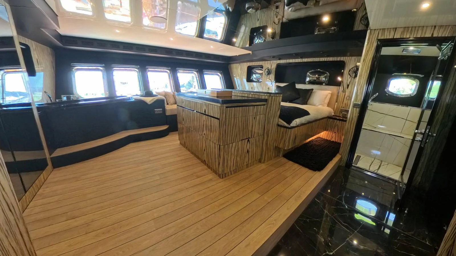 The master stateroom features luxurious wood paneling and ample natural light from large windows. aboard ODISEA Yacht for Sale