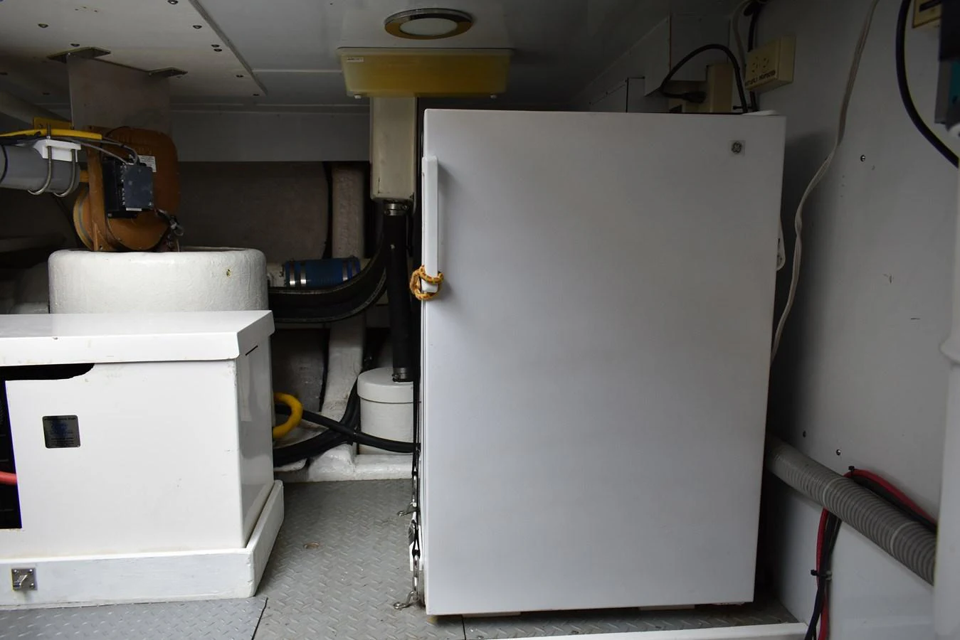 A detailed view of the yacht's utility area featuring a refrigerator and various equipment. aboard 64 OCEAN ALEXANDER Yacht for Sale