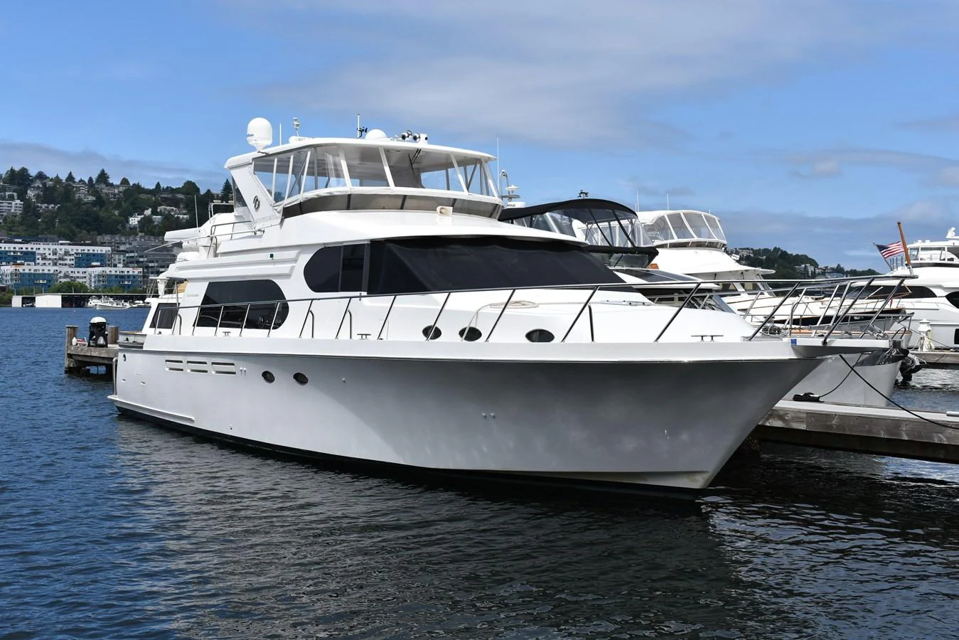 A sleek white yacht is docked in a serene marina, showcasing its elegant design and spacious decks. aboard 64 OCEAN ALEXANDER Yacht for Sale