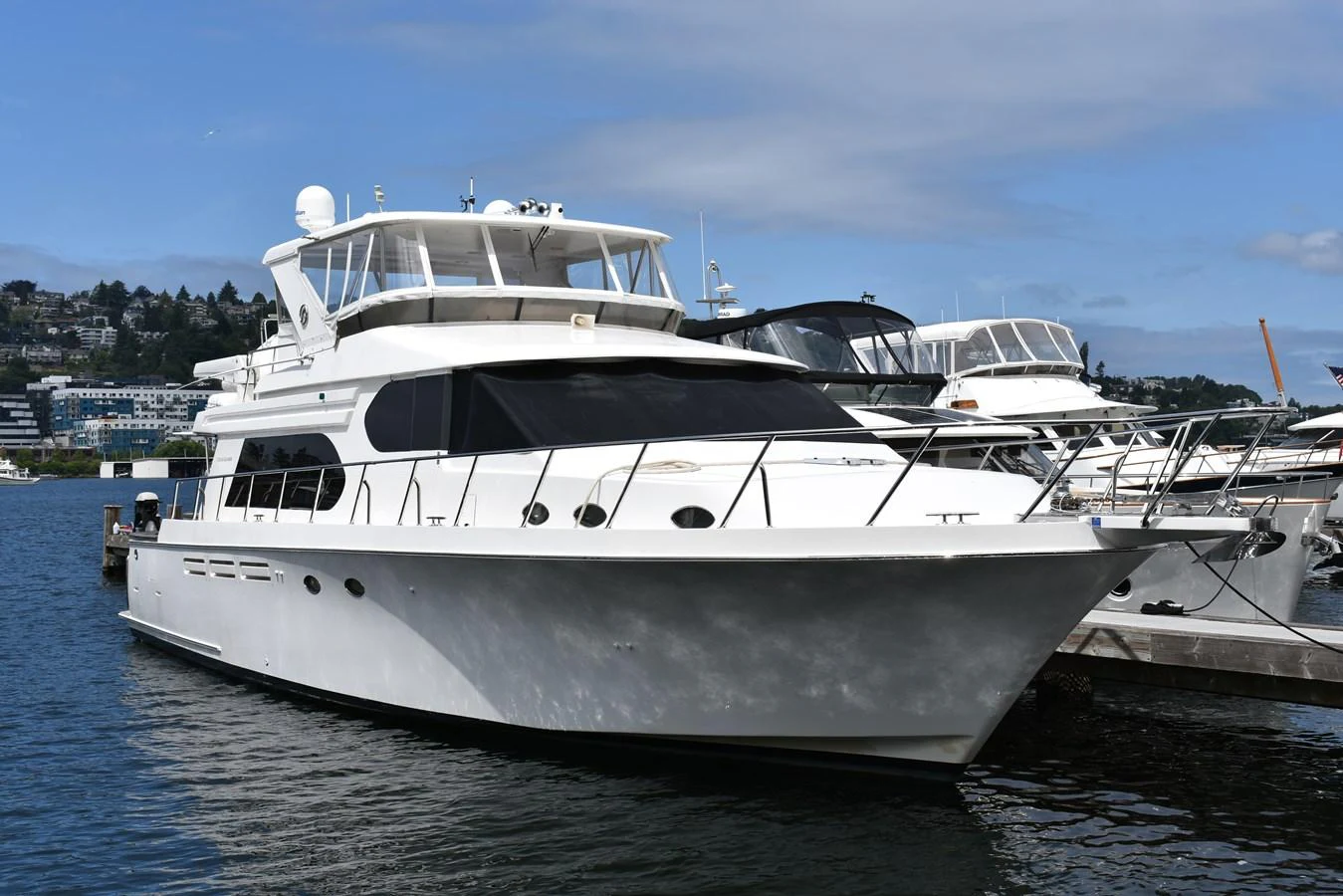 A sleek white yacht is docked at a marina under a clear blue sky. aboard 64 OCEAN ALEXANDER Yacht for Sale