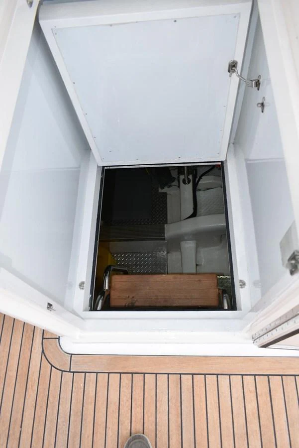 A hatch opens to reveal a ladder leading down to the yacht's lower deck or engine room. aboard 64 OCEAN ALEXANDER Yacht for Sale