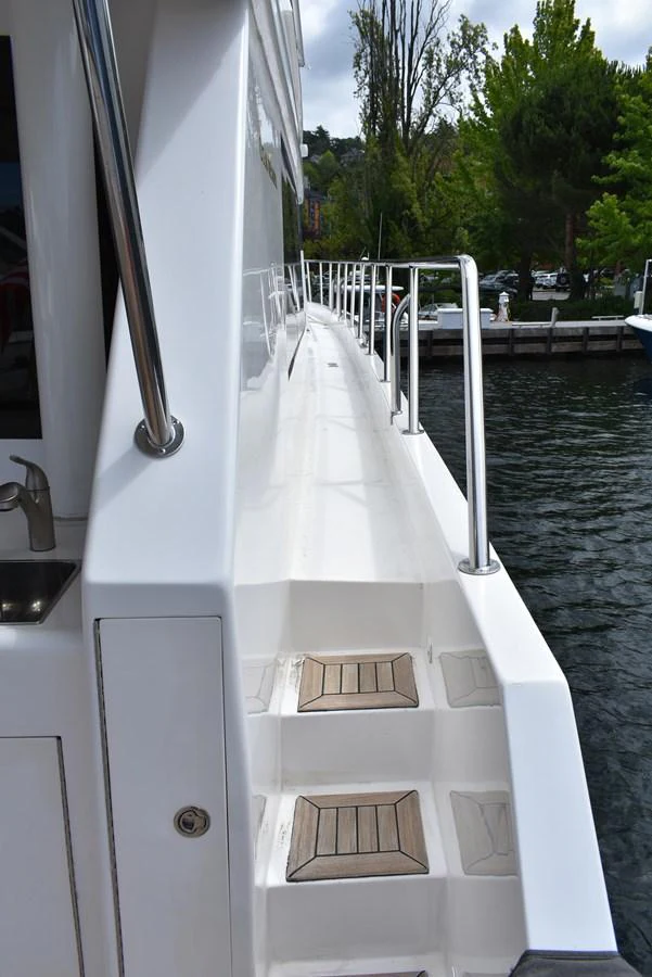 The yacht's side deck features sleek white surfaces and stainless steel railings, leading to the aft deck. aboard 64 OCEAN ALEXANDER Yacht for Sale
