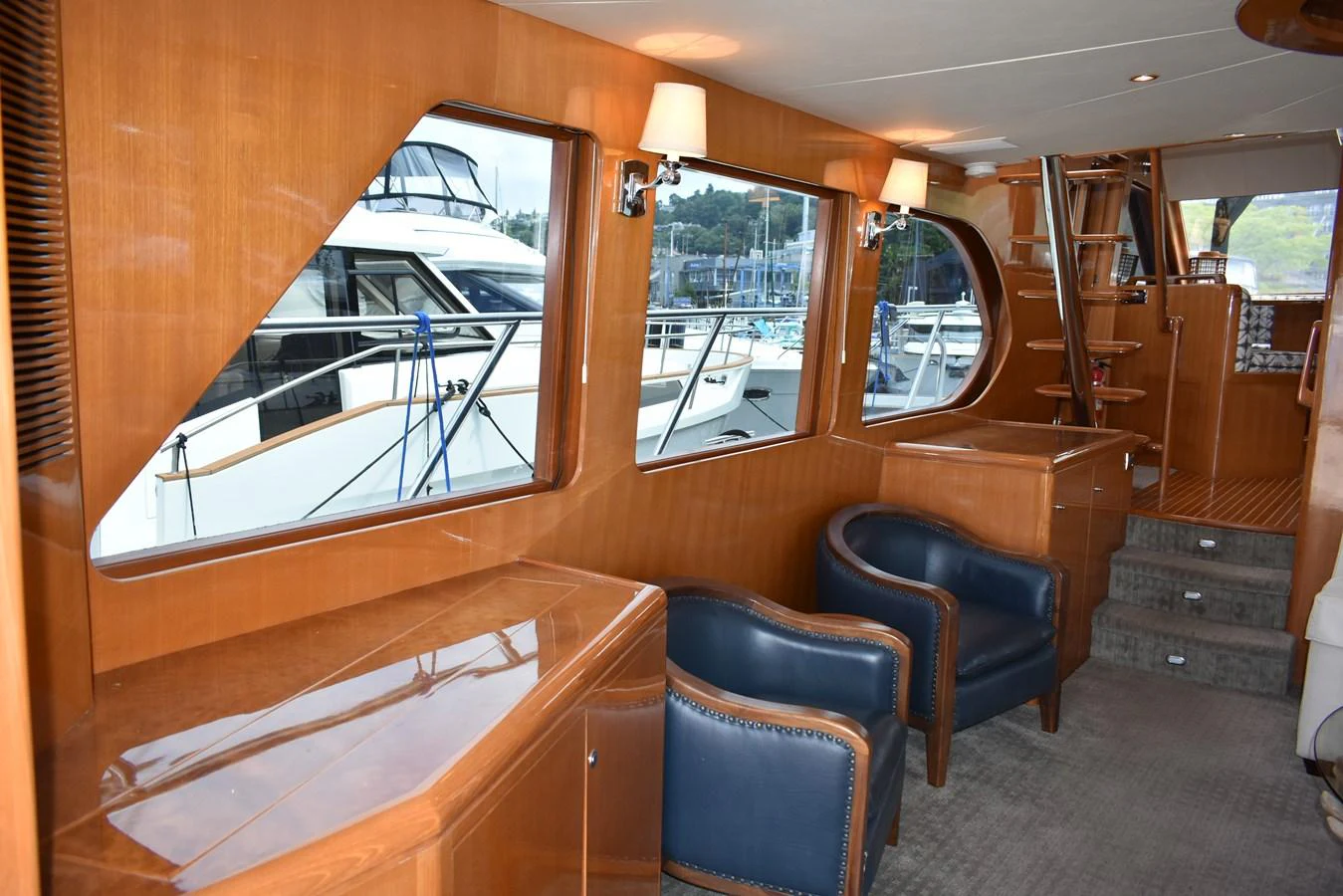 The yacht's interior features a cozy seating area with large windows offering a view of the marina. aboard 64 OCEAN ALEXANDER Yacht for Sale