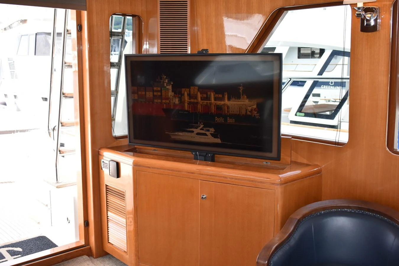 The yacht's interior features a cozy seating area with a flat-screen TV and wooden cabinetry. aboard 64 OCEAN ALEXANDER Yacht for Sale