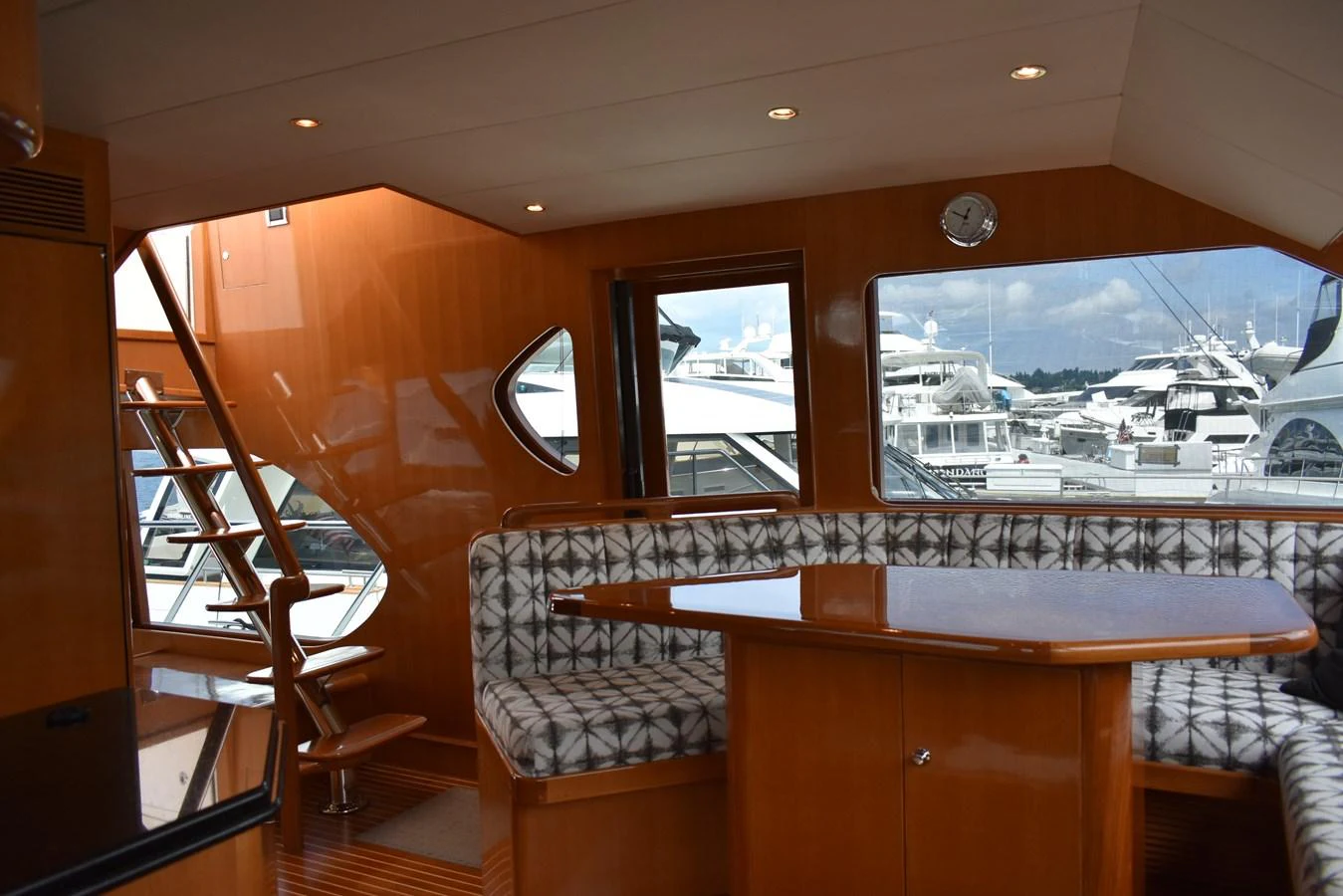 The saloon features a cozy dining area with ample natural light and stylish wood finishes. aboard 64 OCEAN ALEXANDER Yacht for Sale