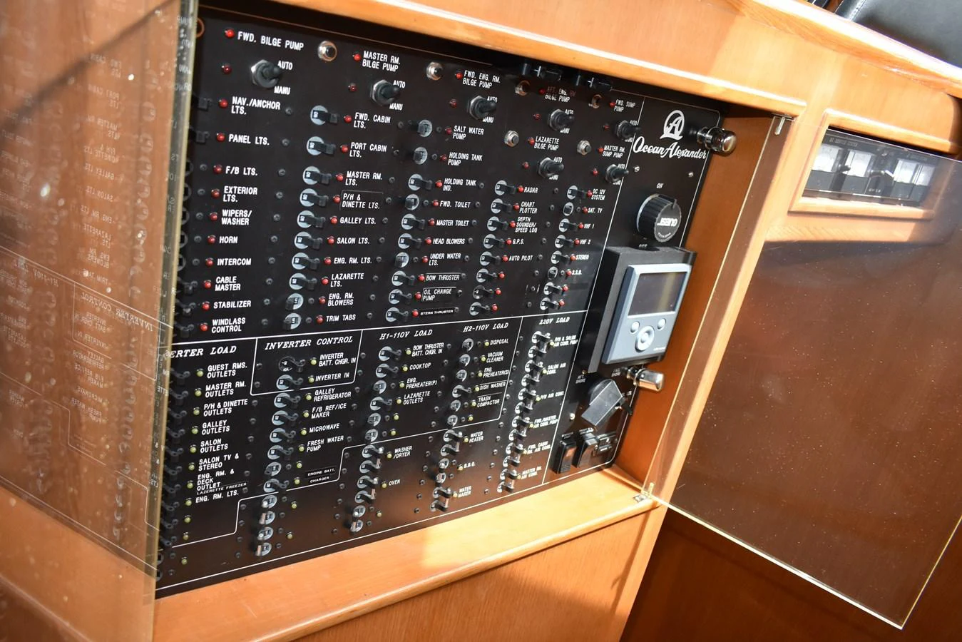 The image showcases the yacht's electrical control panel with various switches and indicators. aboard 64 OCEAN ALEXANDER Yacht for Sale