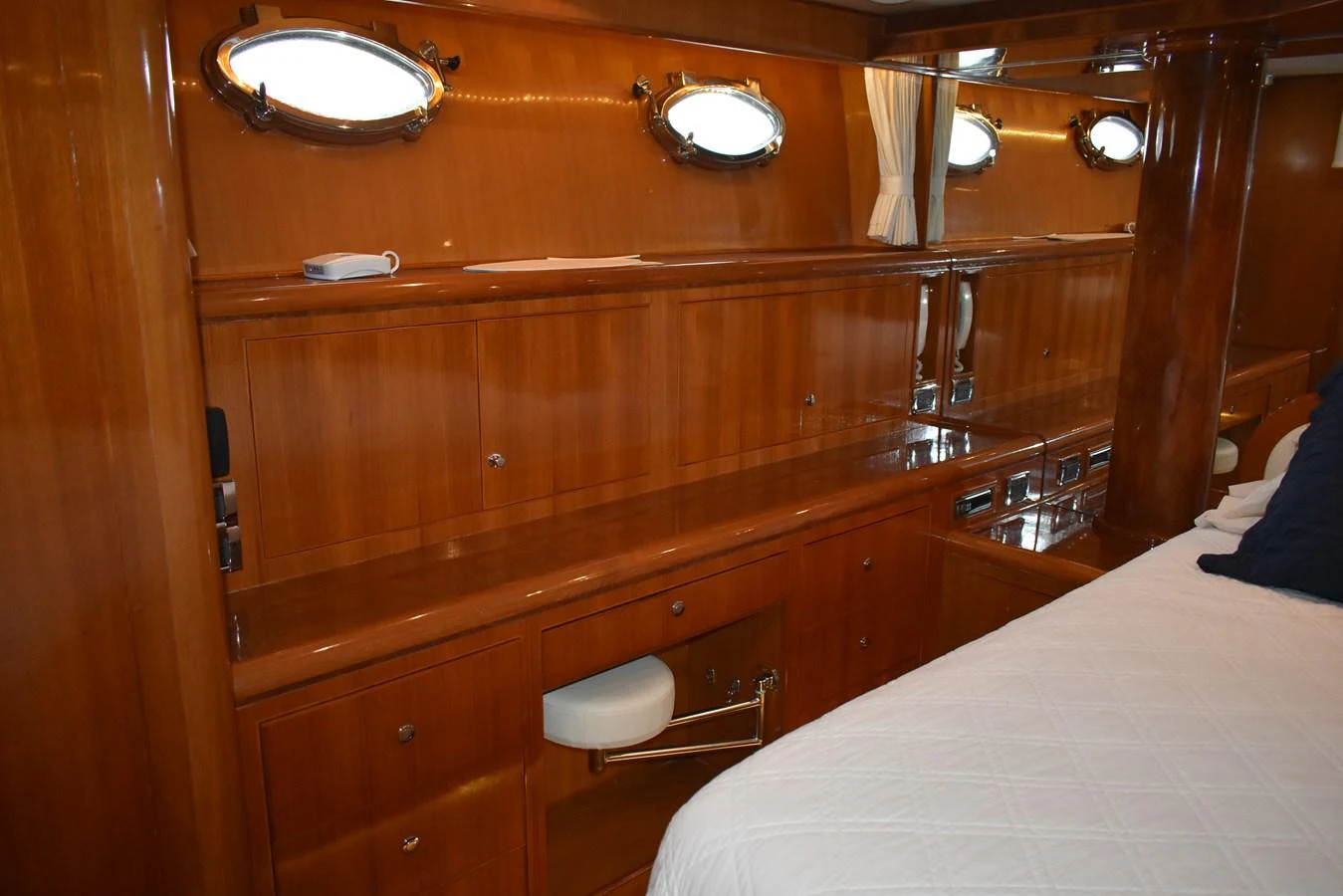 The yacht's interior features polished wooden cabinetry and porthole windows, creating a warm and inviting atmosphere. aboard 64 OCEAN ALEXANDER Yacht for Sale