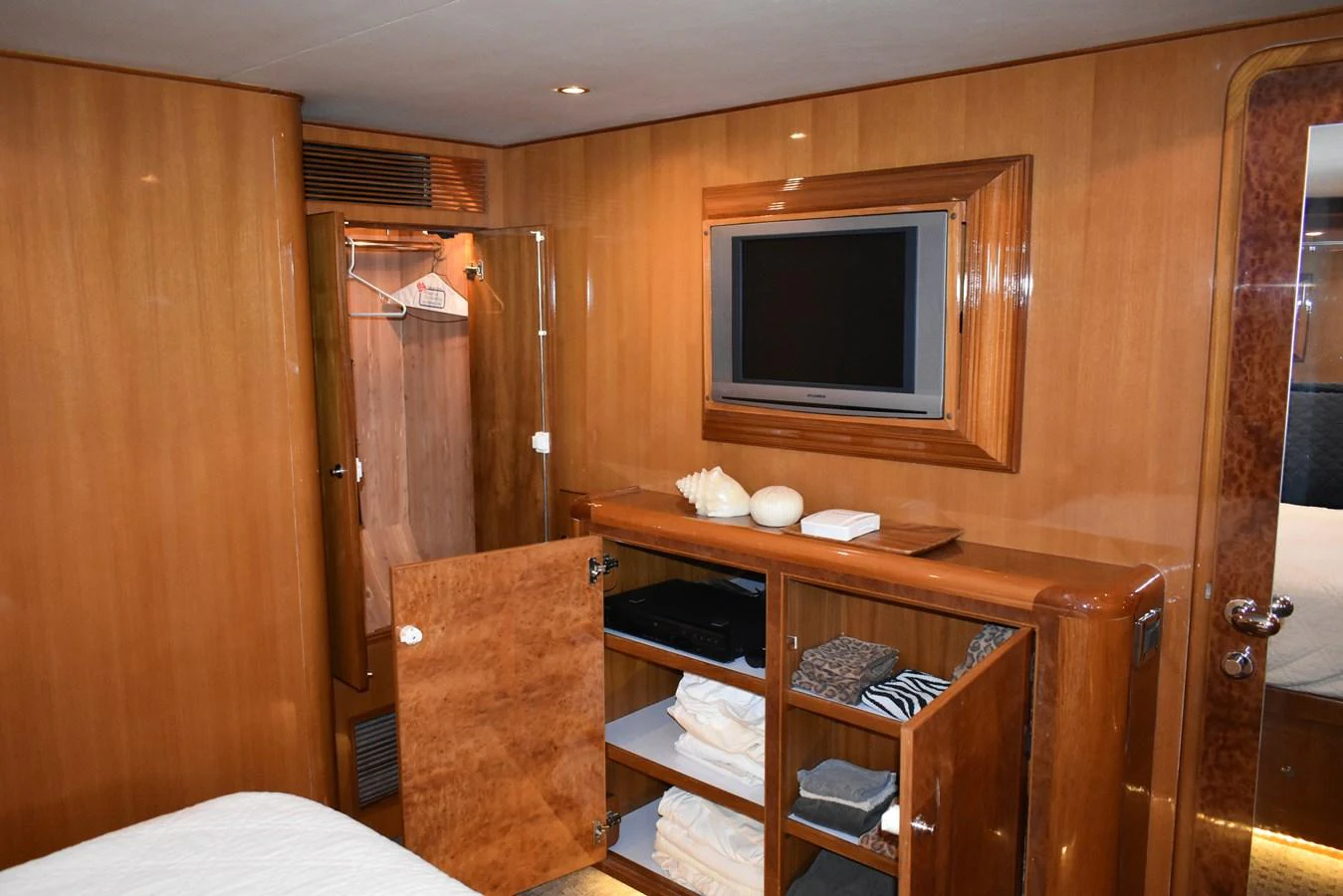 The yacht's interior features a well-organized storage area with a television and wooden cabinetry. aboard 64 OCEAN ALEXANDER Yacht for Sale