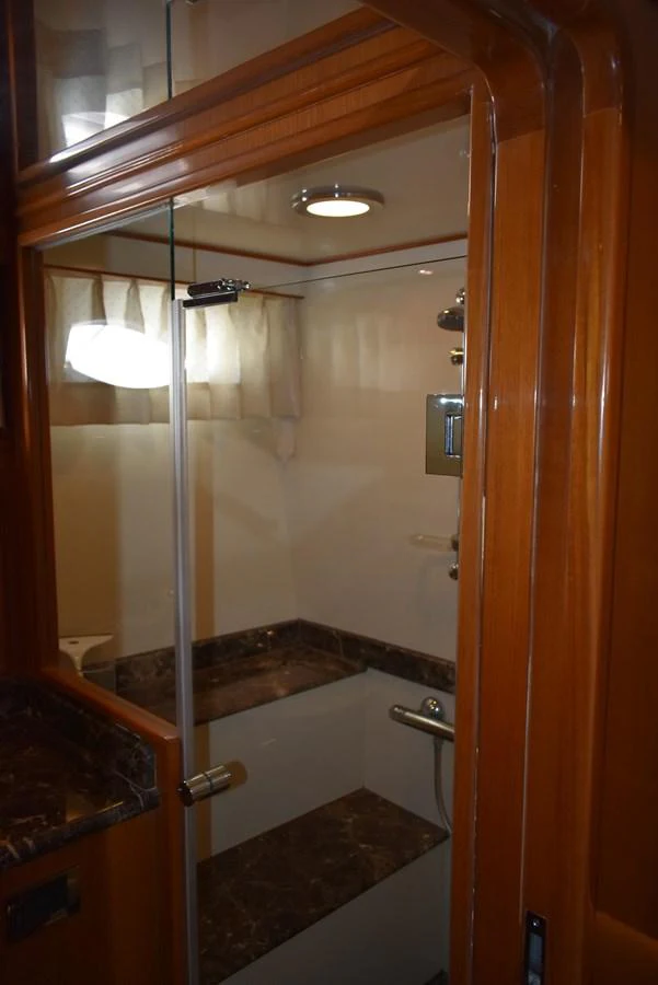 The yacht's bathroom features a sleek design with a glass shower enclosure and marble accents. aboard 64 OCEAN ALEXANDER Yacht for Sale