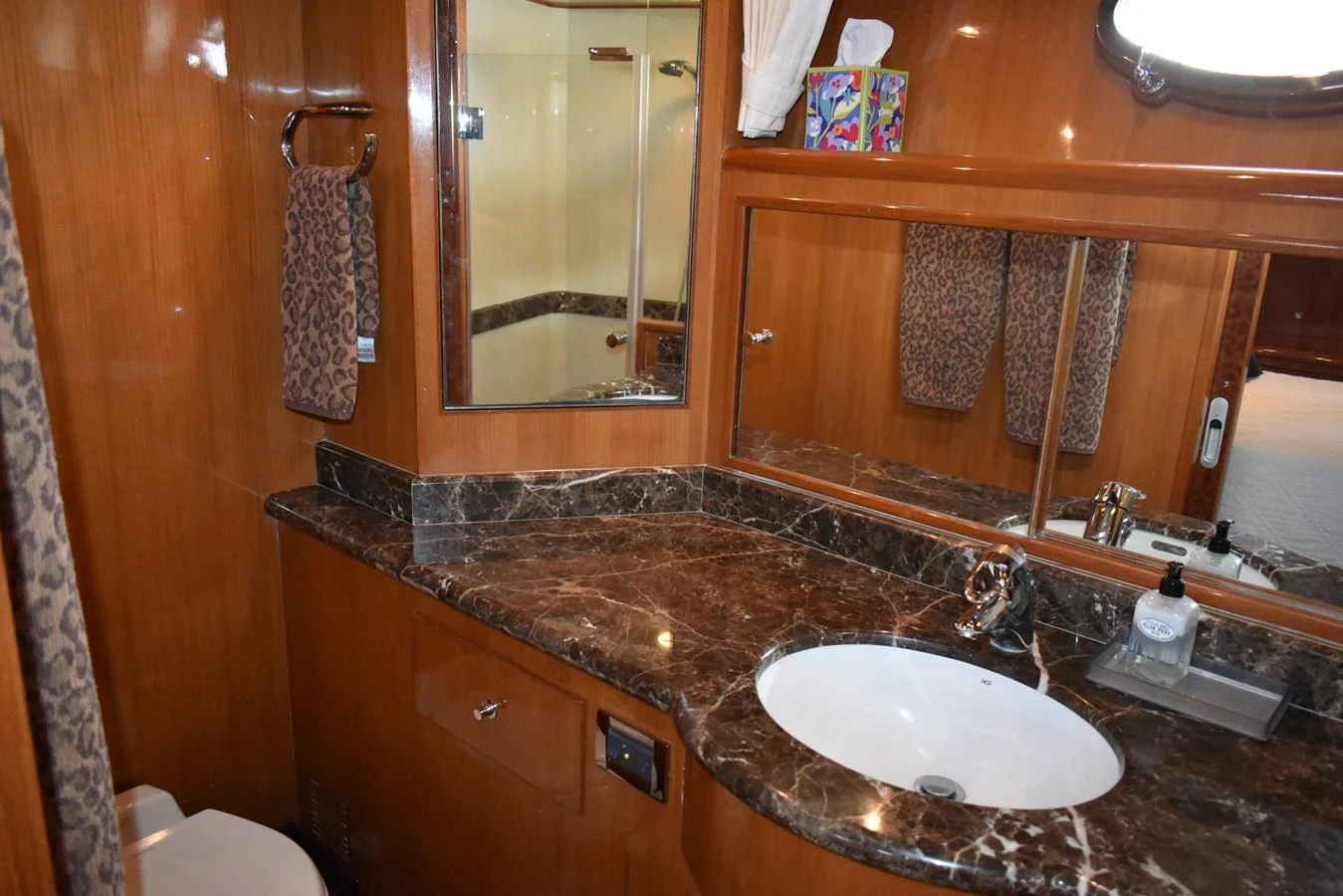 The yacht's bathroom features elegant marble countertops and wooden cabinetry. aboard 64 OCEAN ALEXANDER Yacht for Sale