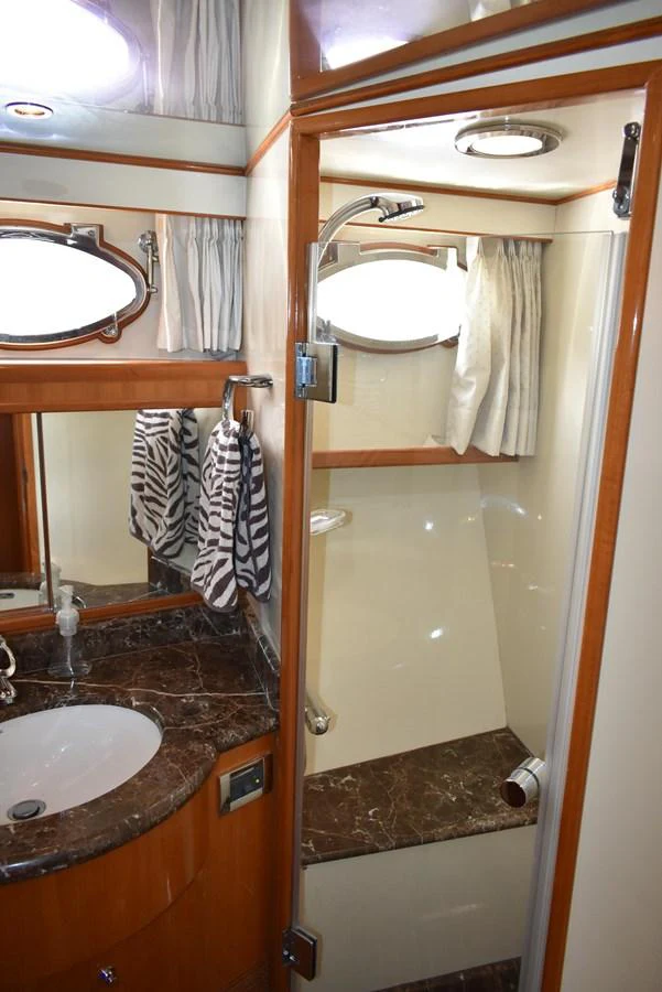 The yacht's bathroom features a sleek design with a marble countertop and a compact shower area. aboard 64 OCEAN ALEXANDER Yacht for Sale