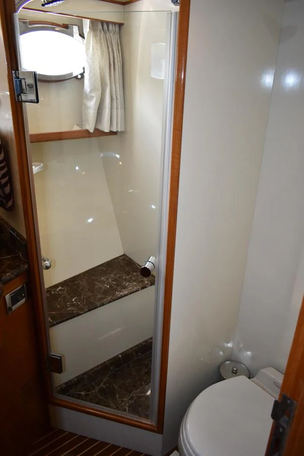The yacht's bathroom features a compact and efficient design with a shower and toilet. aboard 64 OCEAN ALEXANDER Yacht for Sale