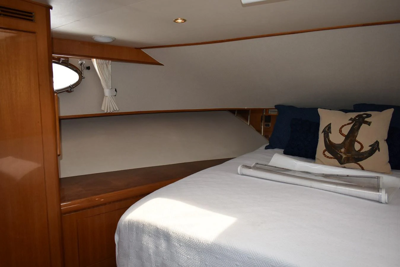 The stateroom features a cozy bed with nautical-themed decor and wooden accents. aboard 64 OCEAN ALEXANDER Yacht for Sale