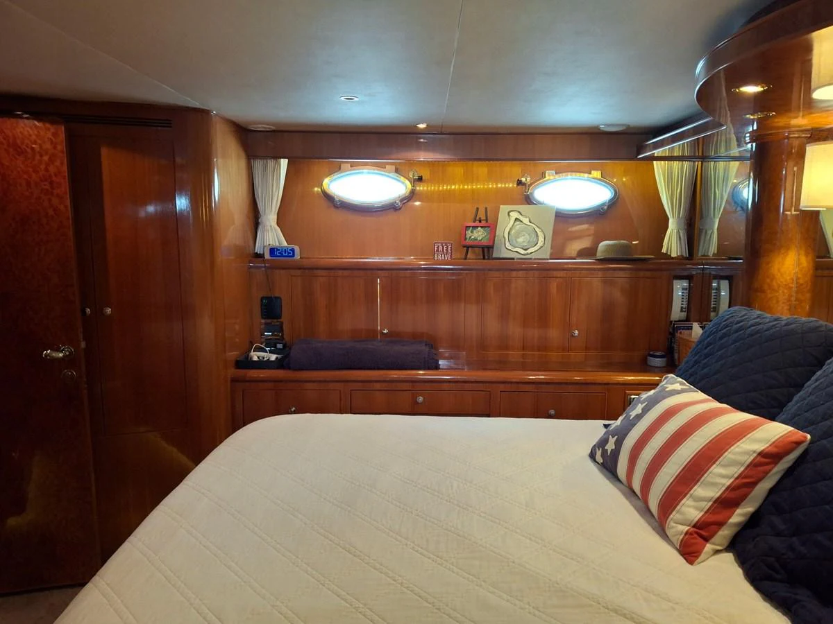 The stateroom features a cozy bed with elegant wooden paneling and nautical decor. aboard 64 OCEAN ALEXANDER Yacht for Sale