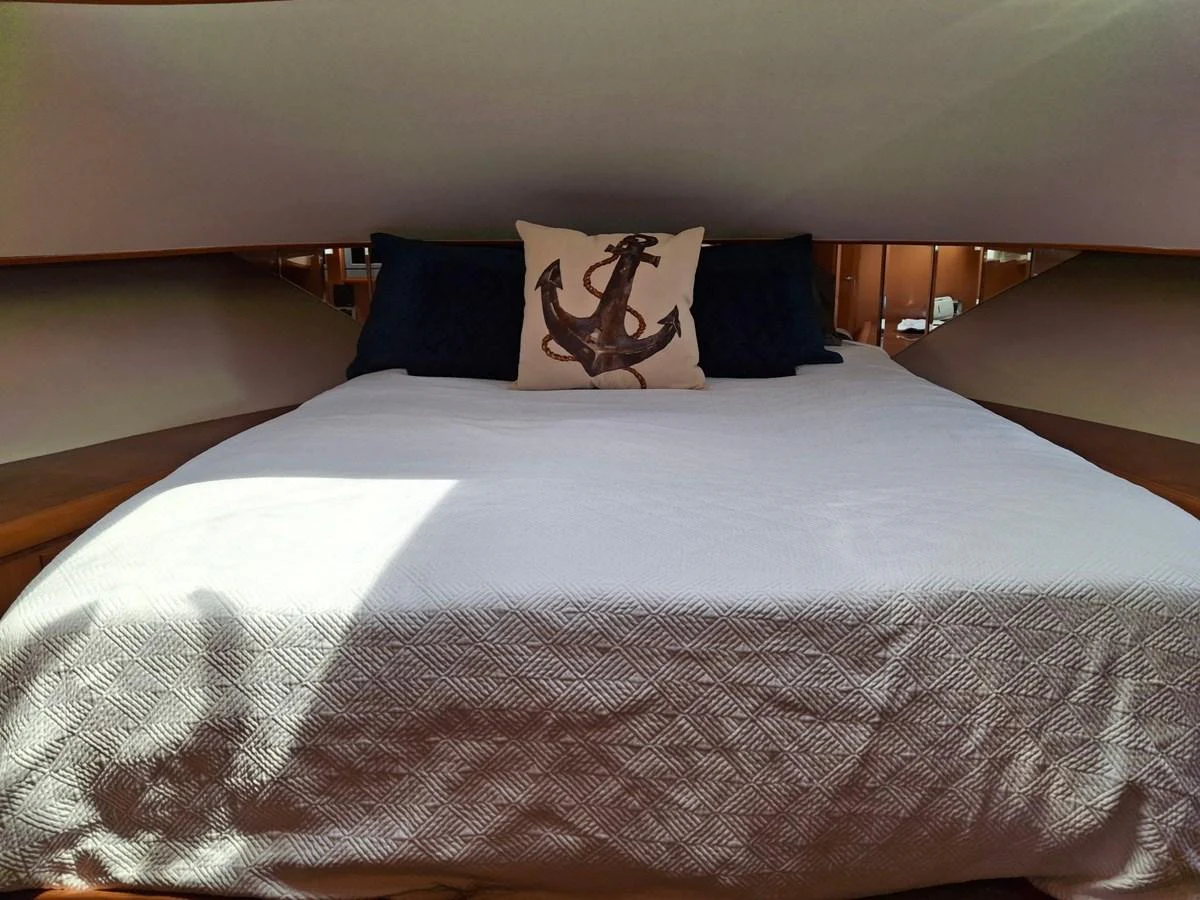 The cozy stateroom features a comfortable bed adorned with nautical-themed decor. aboard 64 OCEAN ALEXANDER Yacht for Sale