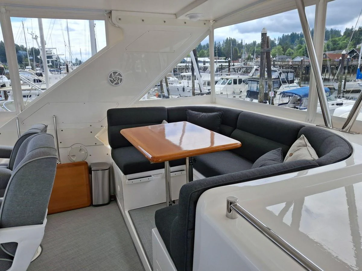 The yacht's salon features a comfortable seating area with a wooden table, perfect for socializing and dining. aboard 64 OCEAN ALEXANDER Yacht for Sale