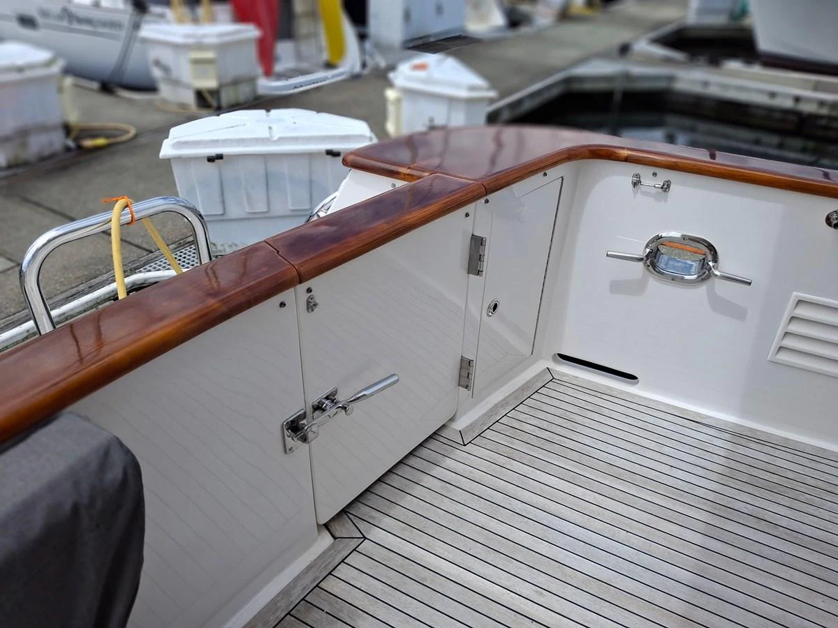 The image showcases a well-maintained deck area with polished wood accents and storage compartments. aboard 64 OCEAN ALEXANDER Yacht for Sale