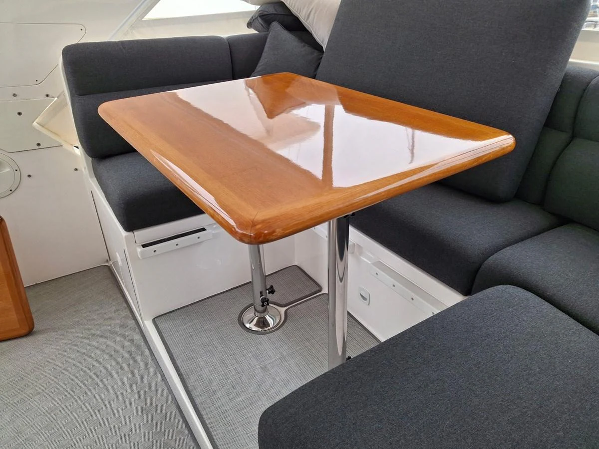The salon features a sleek wooden table surrounded by comfortable dark grey seating. aboard 64 OCEAN ALEXANDER Yacht for Sale