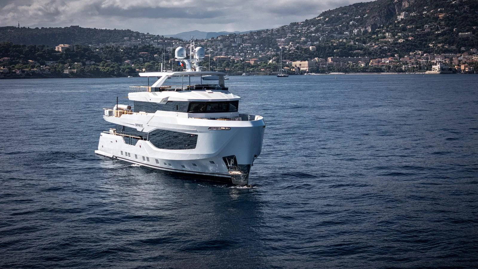 A luxurious yacht cruises gracefully on the open water with a scenic coastal backdrop. aboard NUMARINE 37XP#22 Yacht for Sale