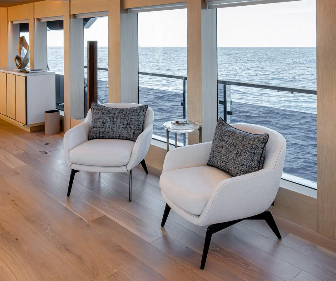 The yacht's interior features a serene seating area with ocean views through large windows. aboard NUMARINE 37XP#22 Yacht for Sale