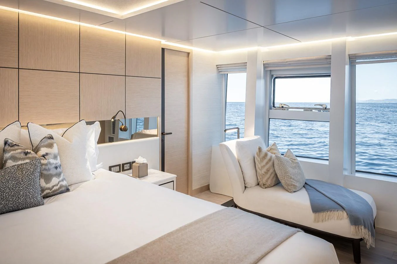 The stateroom offers a serene retreat with a large bed, chaise lounge, and ocean views through expansive windows. aboard NUMARINE 37XP#22 Yacht for Sale